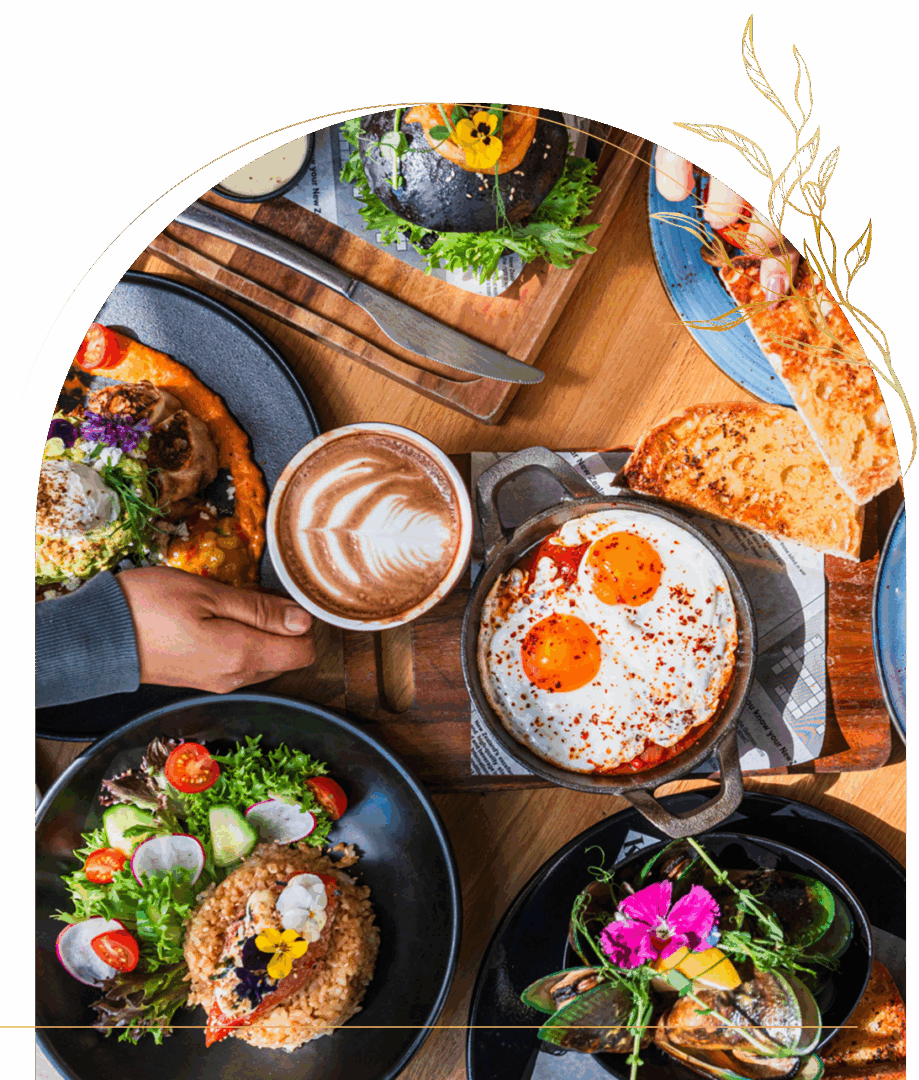 Assorted brunch dishes with coffee on wooden table.